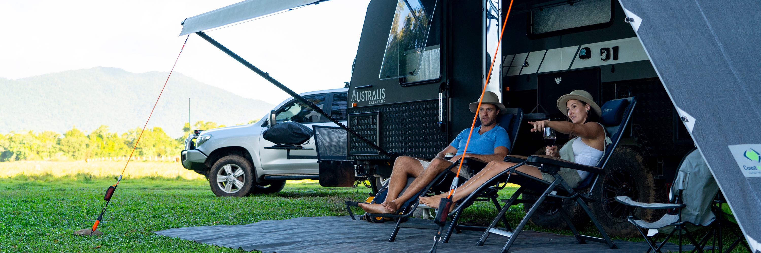 Couple sitting in front of caravan with awning setup | Caravan Accessories | Caravan Awning Accessories | Tiegear Guy Rope | Caravan Pack