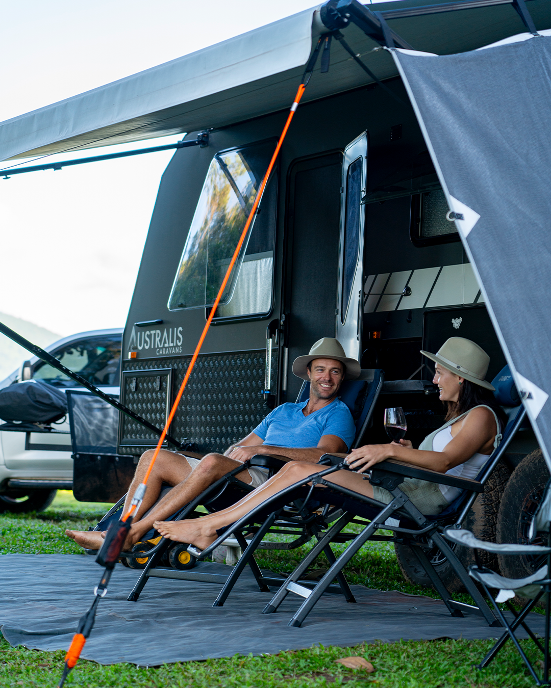 Couple sitting in front of caravan with awning setup | Caravan Accessories | Caravan Awning Accessories | Tiegear Guy Rope | Caravan Pack
