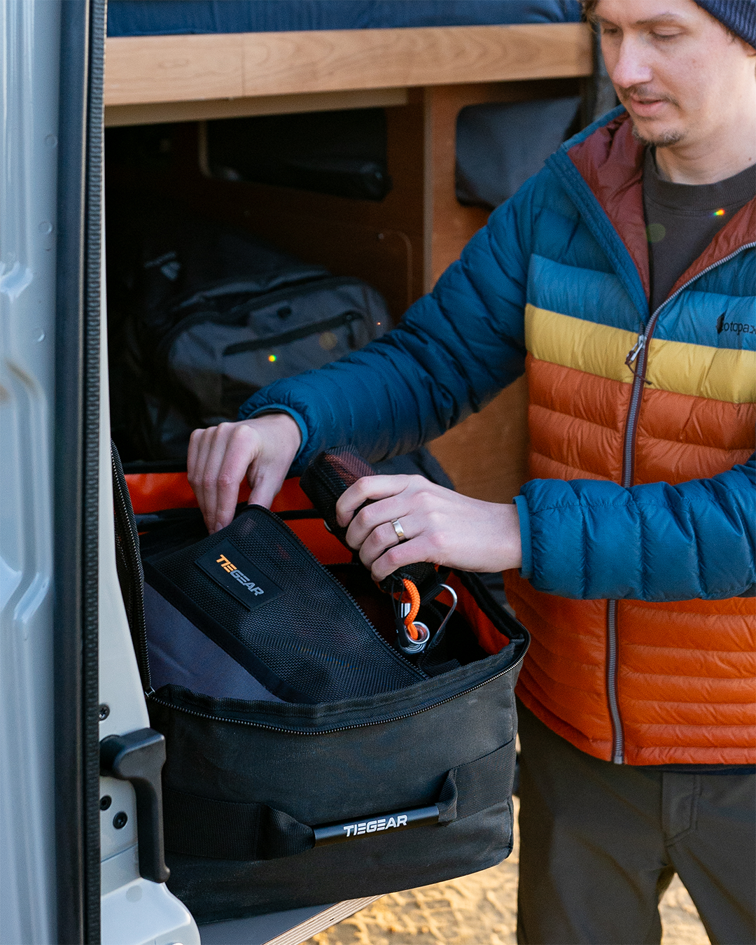 Guy pulling out tie down gear from storage bag | Camping Storage Solutions | Tiegear Accessories